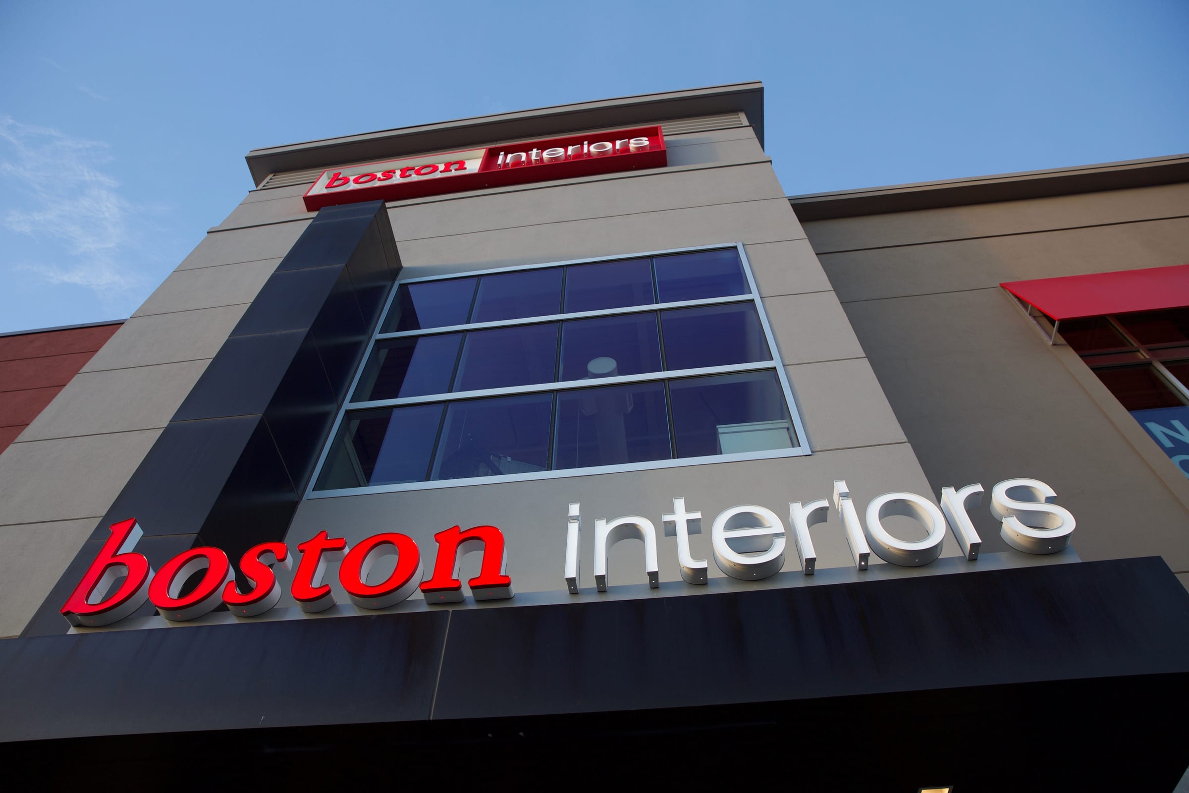 Red and white boston interiors channel letters on a modern facade