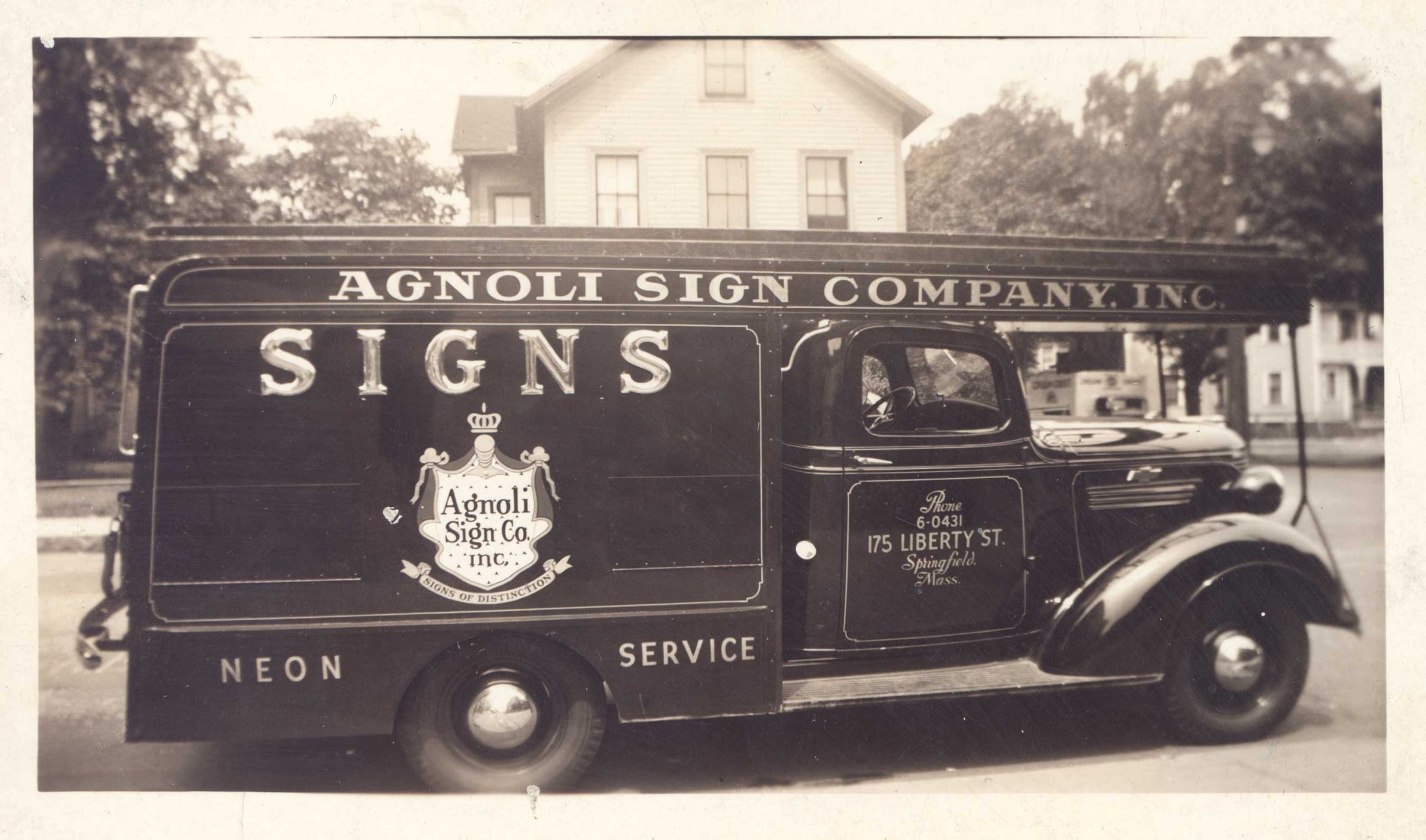 Vintage black and white photo of an Agnoli Sign Company Inc. truck lettered Signs, Neon, Service