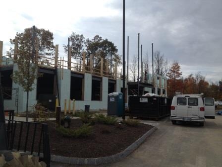 A finished commercial building from the street with a work van parked out front