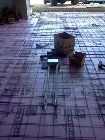 Boxes and stubbed conduit set in the reinforcing mesh of a floor slab