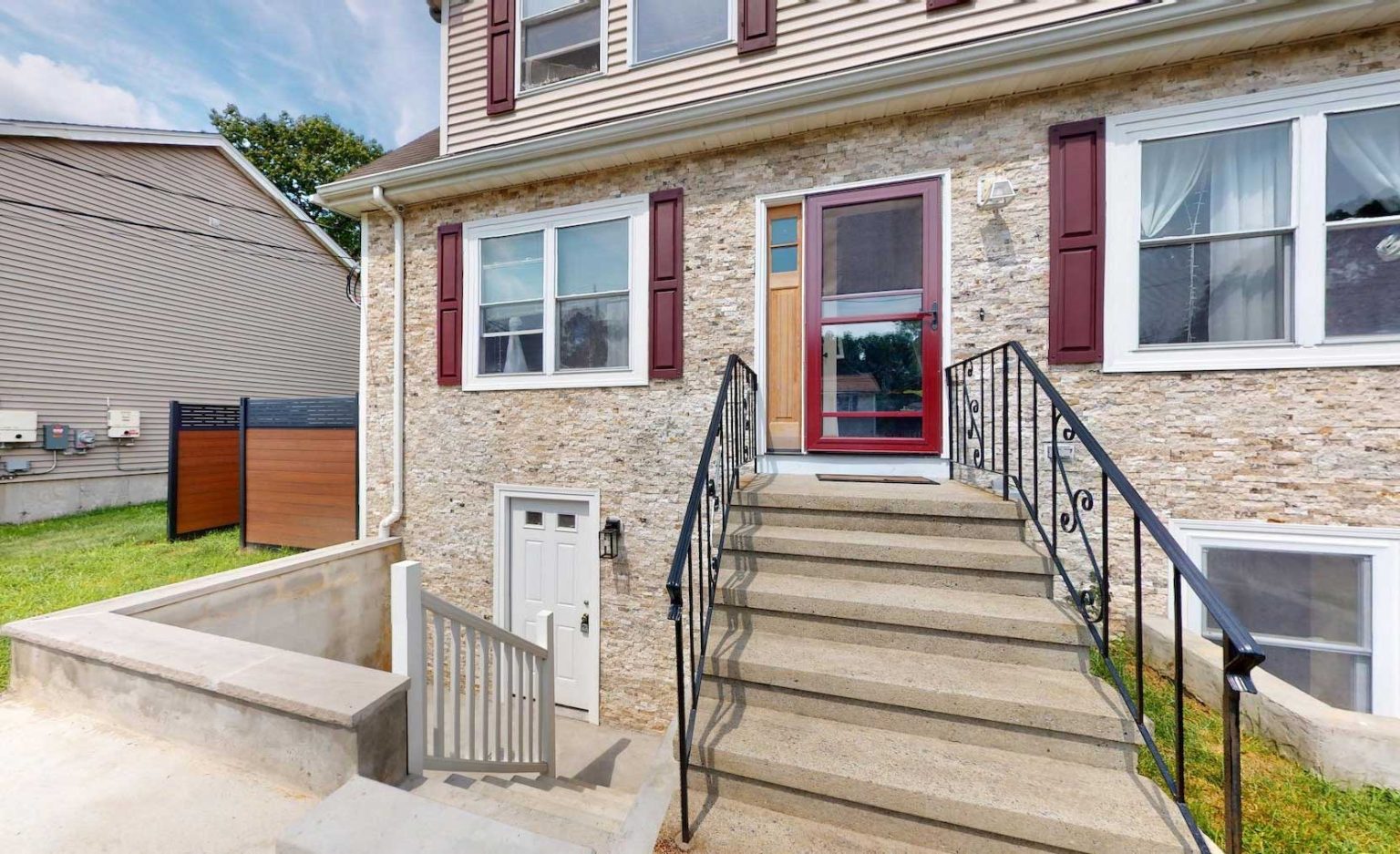 A Boston house with a separate below-grade basement entrance built beside the main red front door