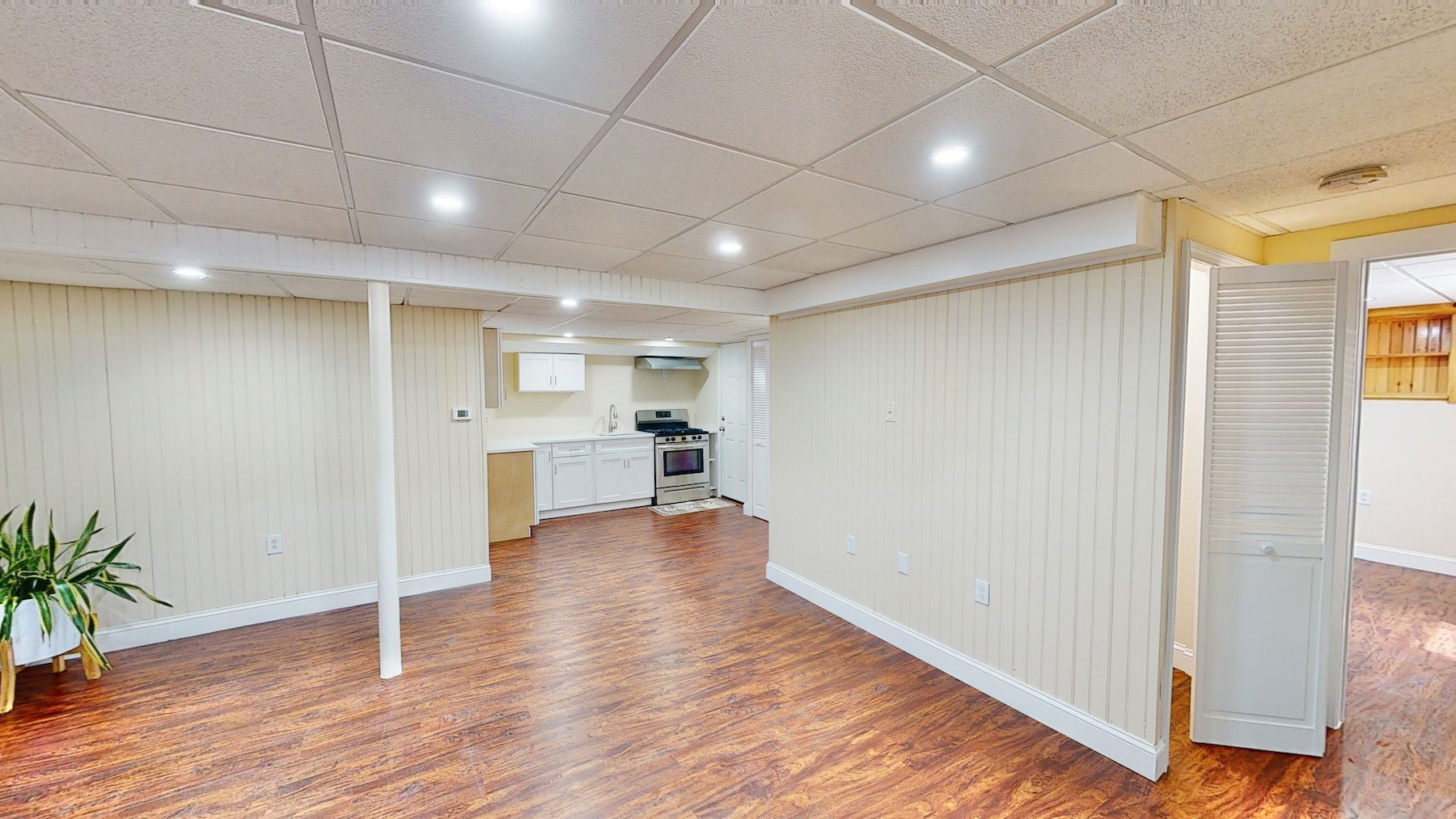 The finished basement unit: open living and dining space leading to a full kitchen
