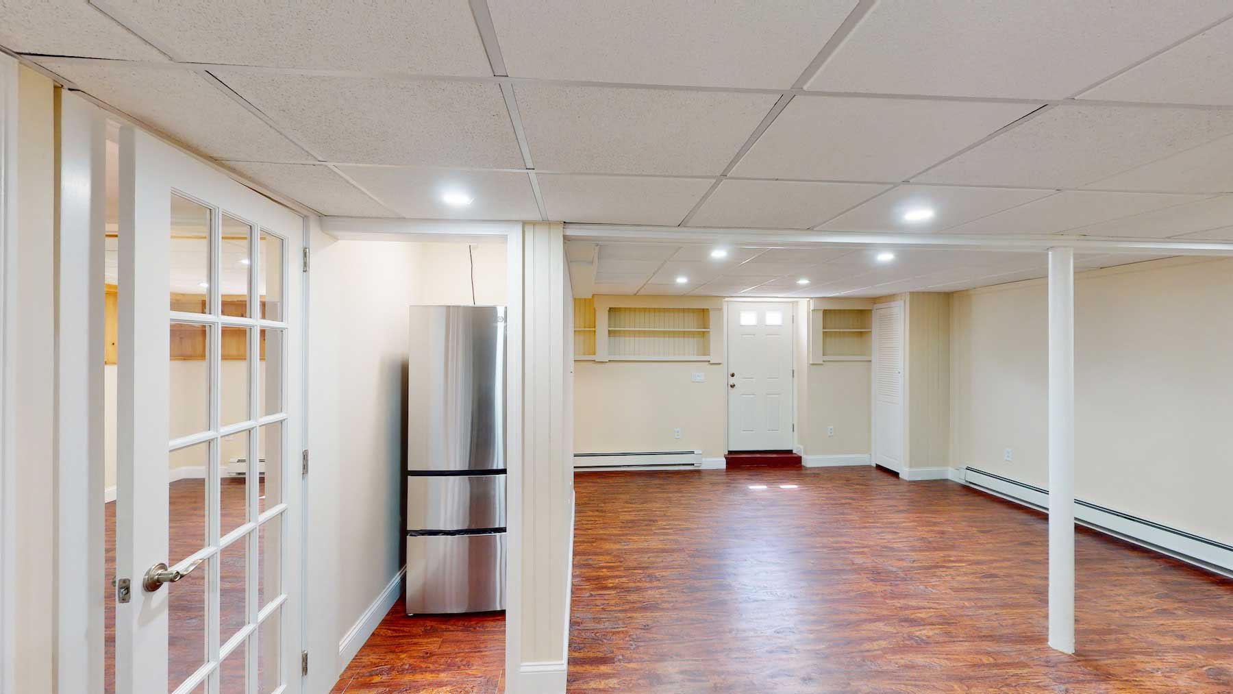The same finished basement unit seen from the kitchen end toward the living space