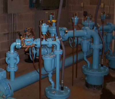 Painted pump piping, valves and gauges inside a station