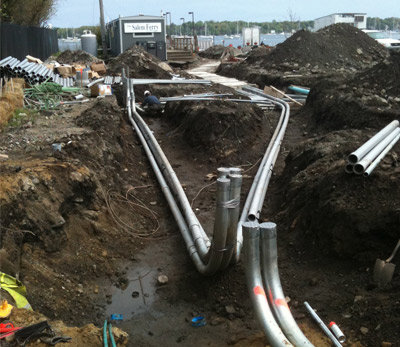 Large conduit sweeps laid in an open trench on a waterfront work site