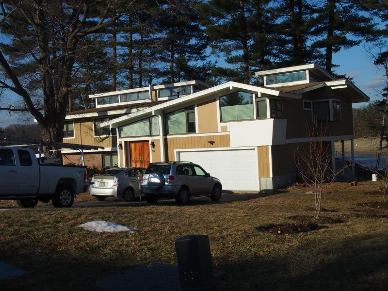 Exterior of a contemporary house with shed dormers, new siding and an attached garage