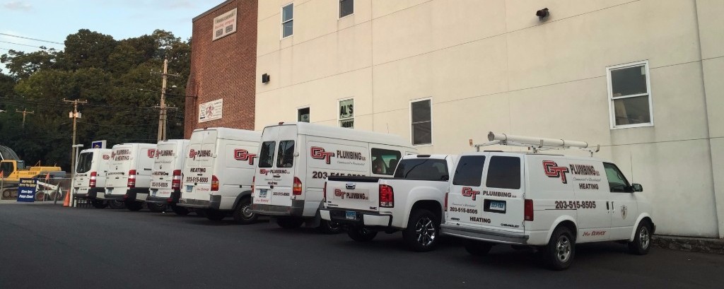 GT Plumbing vans and trucks lined up outside the shop