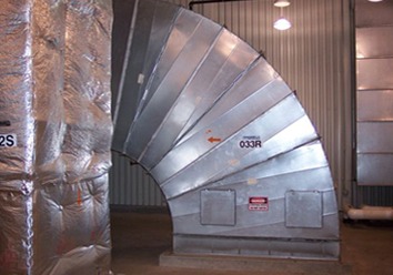 A large galvanized duct elbow assembled in the shop