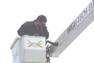 High-Tech Electrical crew member working from the company aerial bucket truck