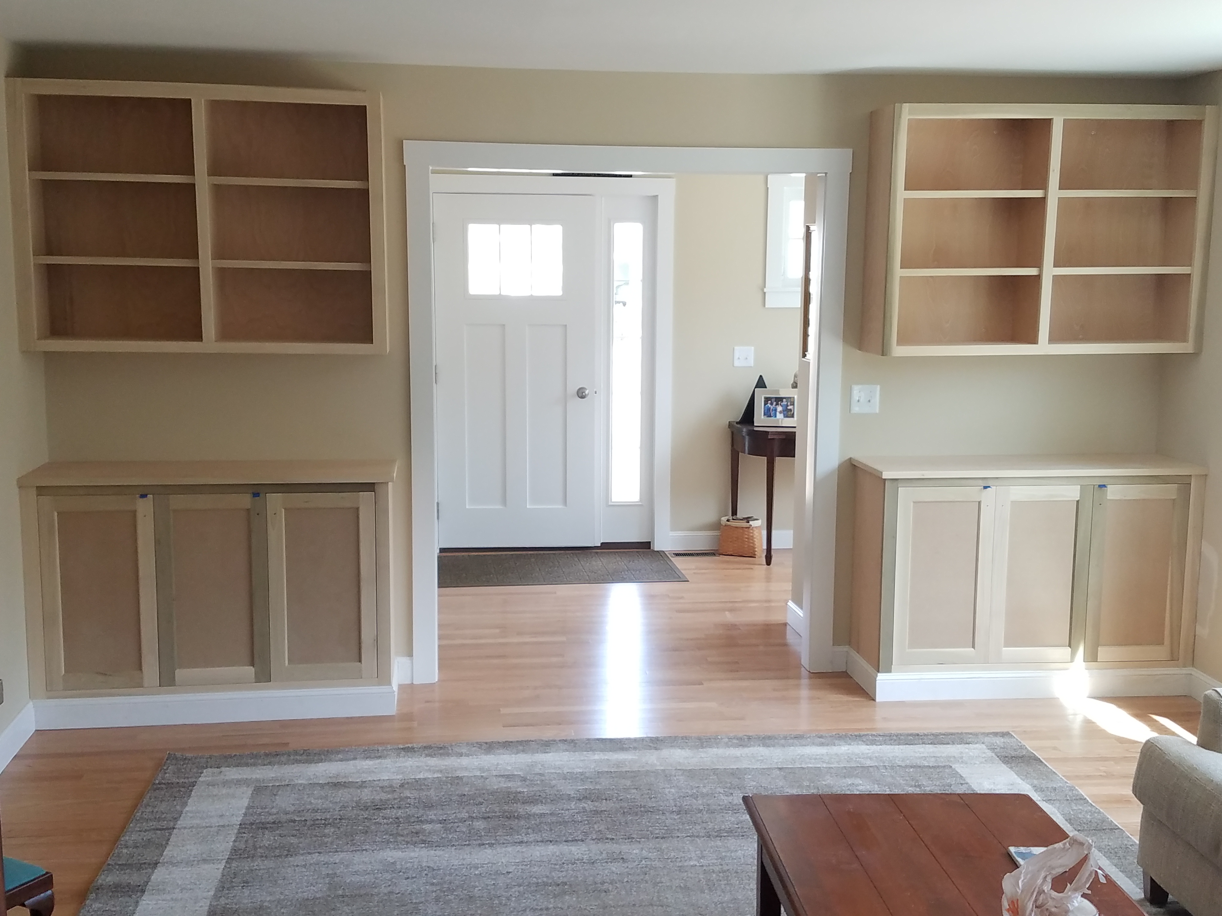 Custom built-in bookcases and cabinets flanking a doorway in a finished living room