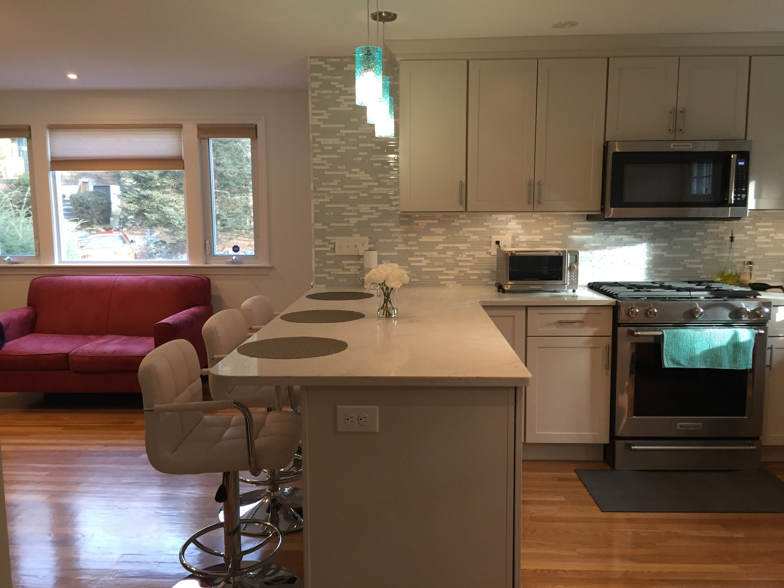 Open kitchen with breakfast bar and stools beside a living area