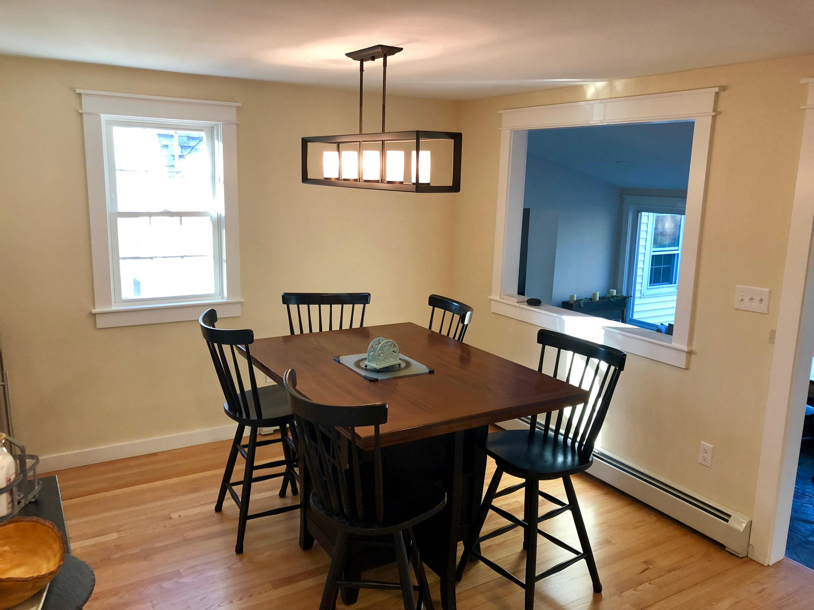 Dining room with a pendant light and a wide opening to the next room