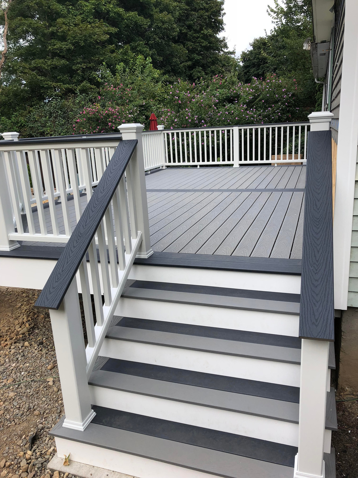 Composite deck and stairs with white rails and dark grey trim