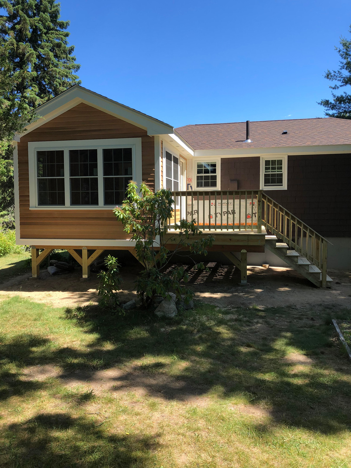 Cedar-sided addition with new windows and a deck with stairs