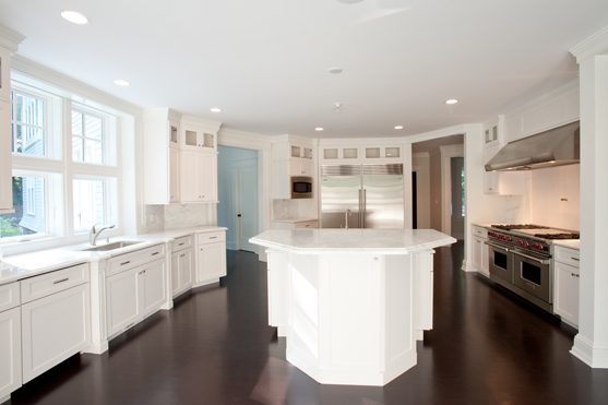 White kitchen with a painted island and dark stained hardwood floor