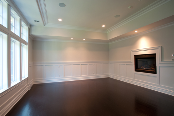 Room with paneled wainscot, a fireplace and a dark stained hardwood floor