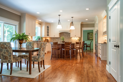 Kitchen and dining area with pendant lights over an island and hardwood floors