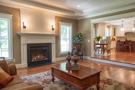 Living room with a painted mantel and hearth opening through to the kitchen