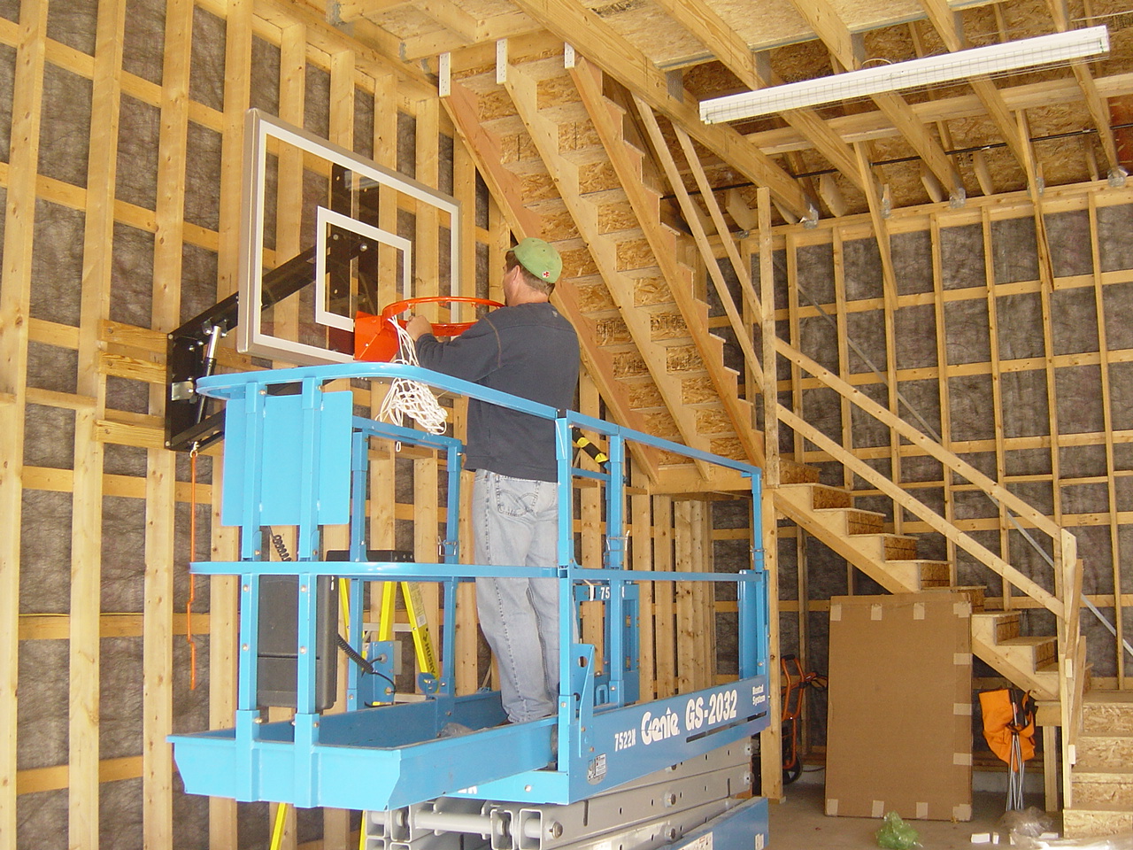 A lift raised inside an unfinished timber-framed barn.