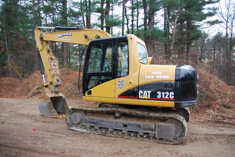 A CAT 312C excavator with the Miles Of Excavating name on the boom and 508 384-9590 painted on the machine