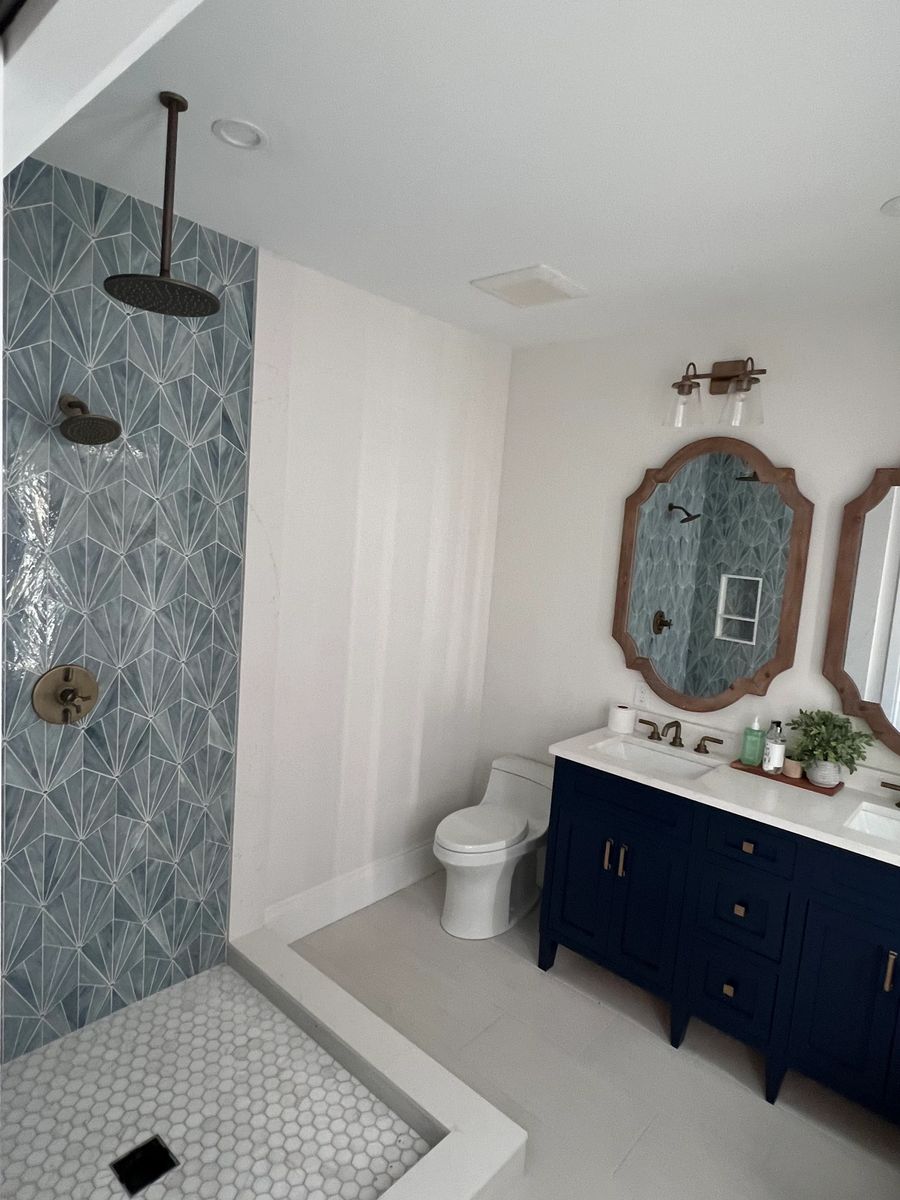 Finished bathroom with a tiled walk in shower, rain head and a blue vanity