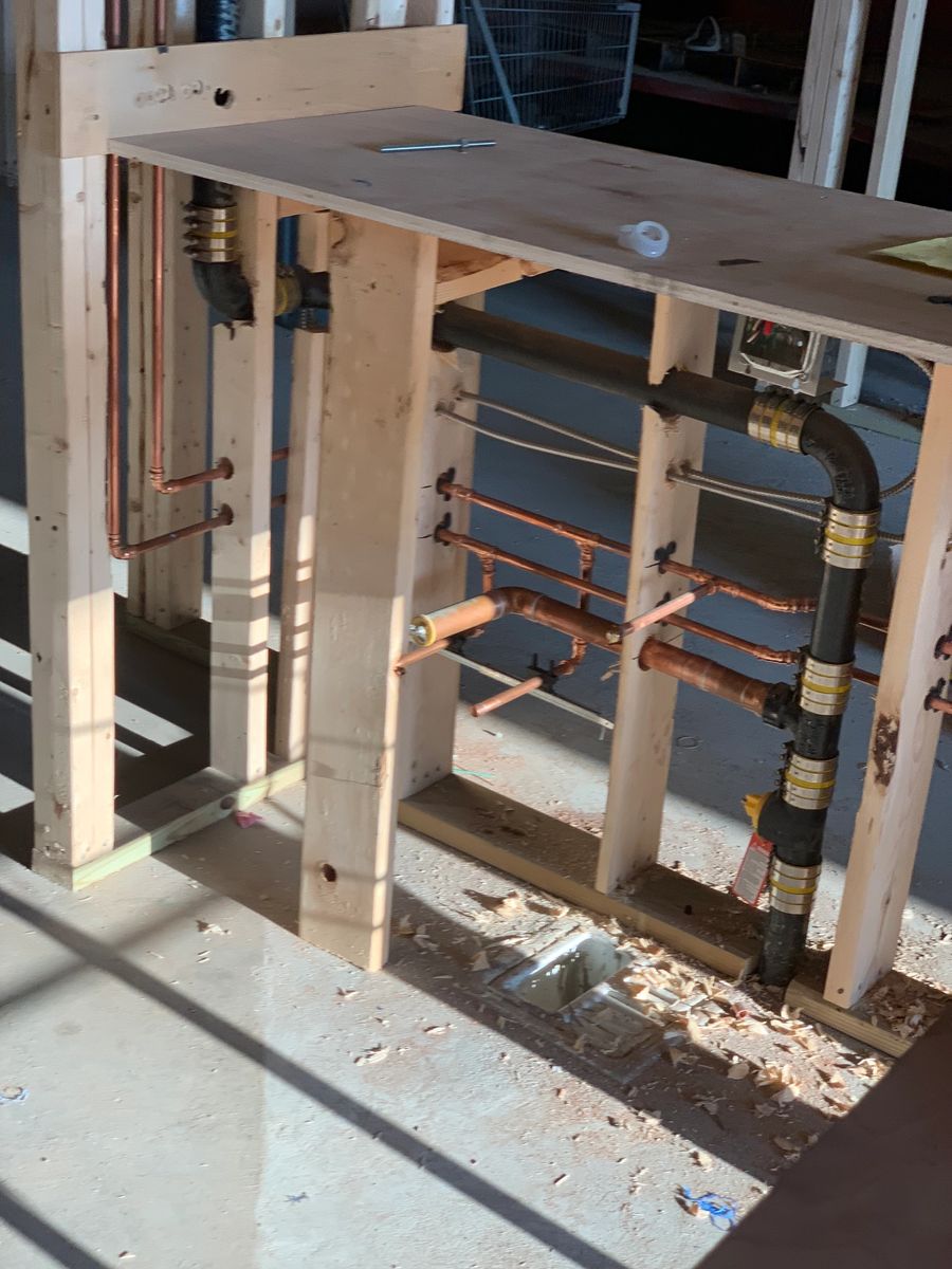 Copper supply lines running horizontally through a framed wall