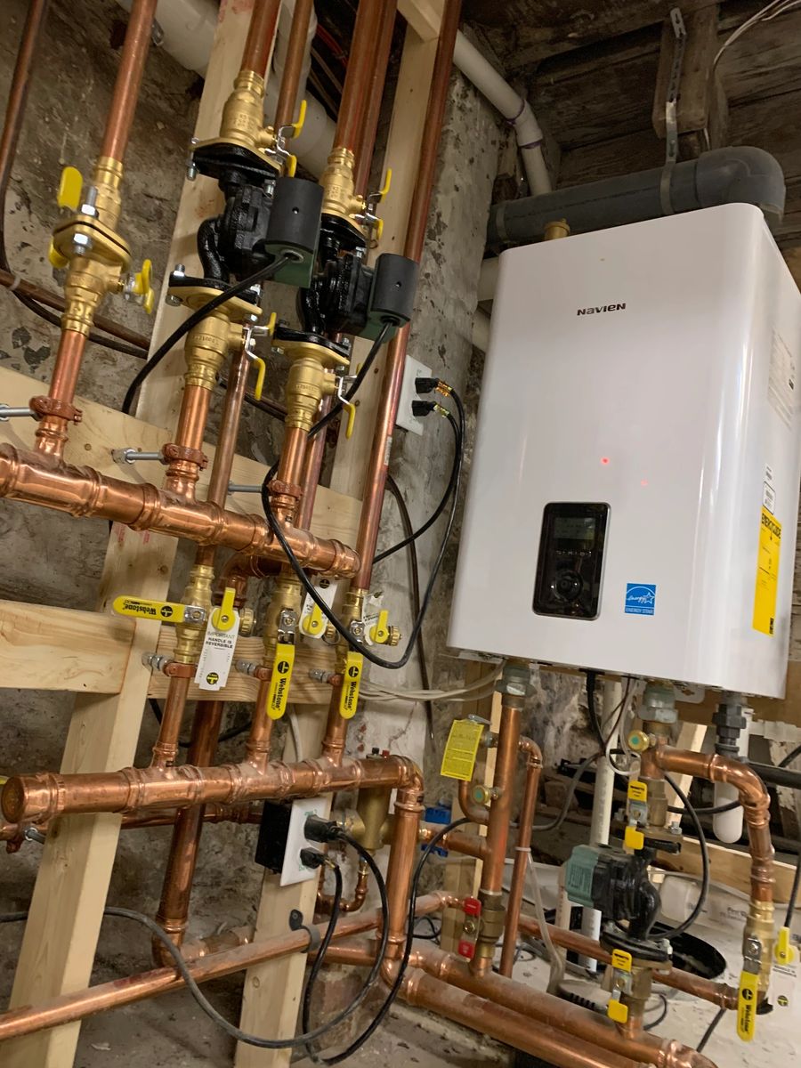 Tankless unit fed by a soldered copper manifold with yellow handled valves