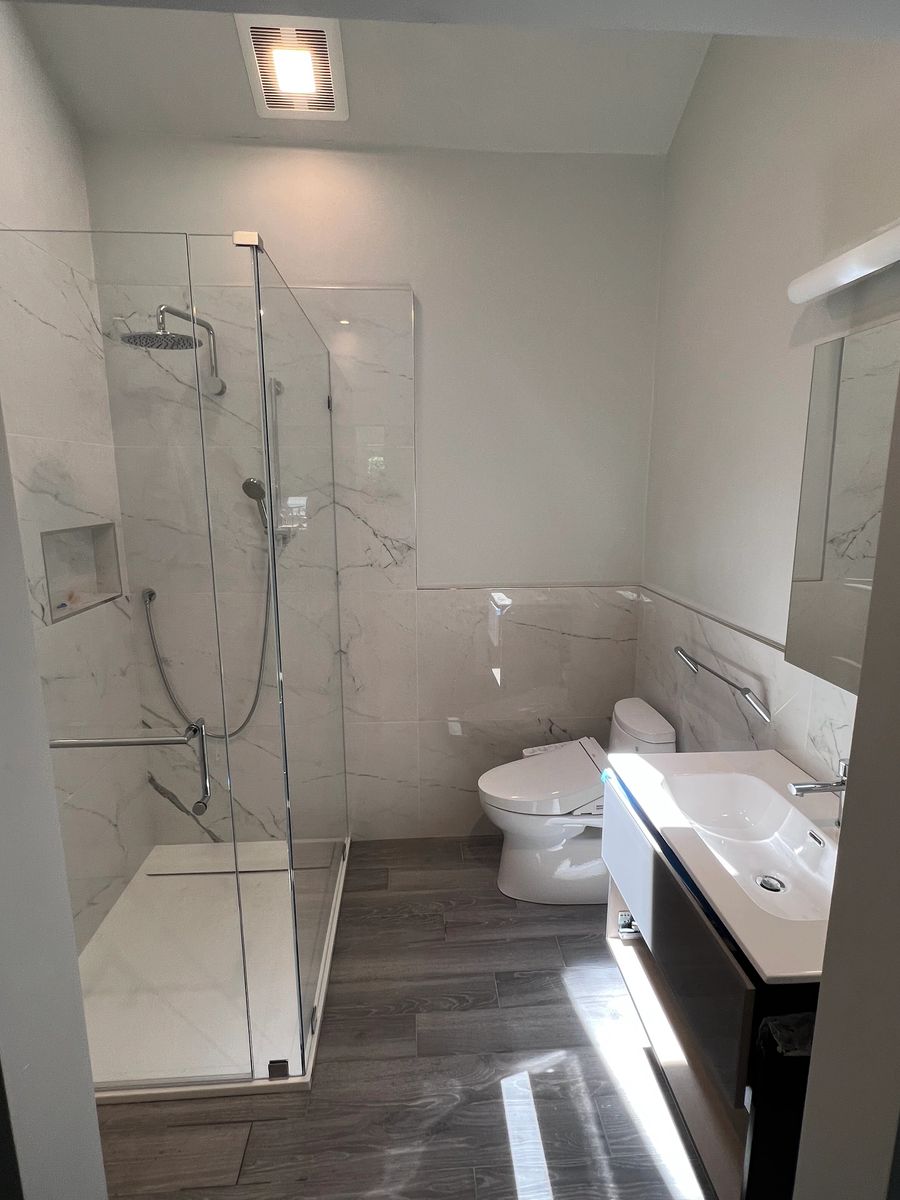 Small full bathroom with a glass shower, toilet and floating vanity