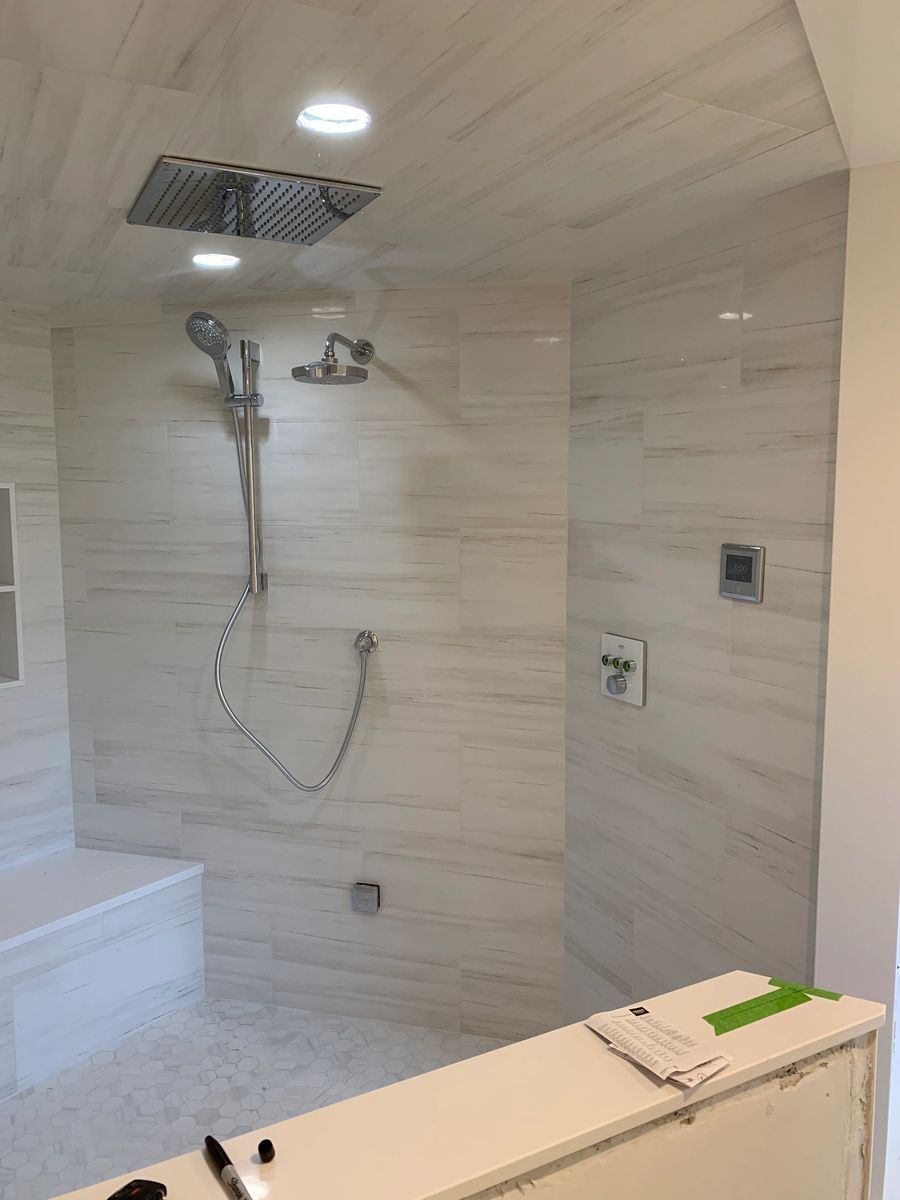 Large format tile shower with a ceiling mounted rain head and hand shower