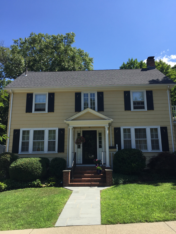 Yellow center-entrance colonial with a new roof