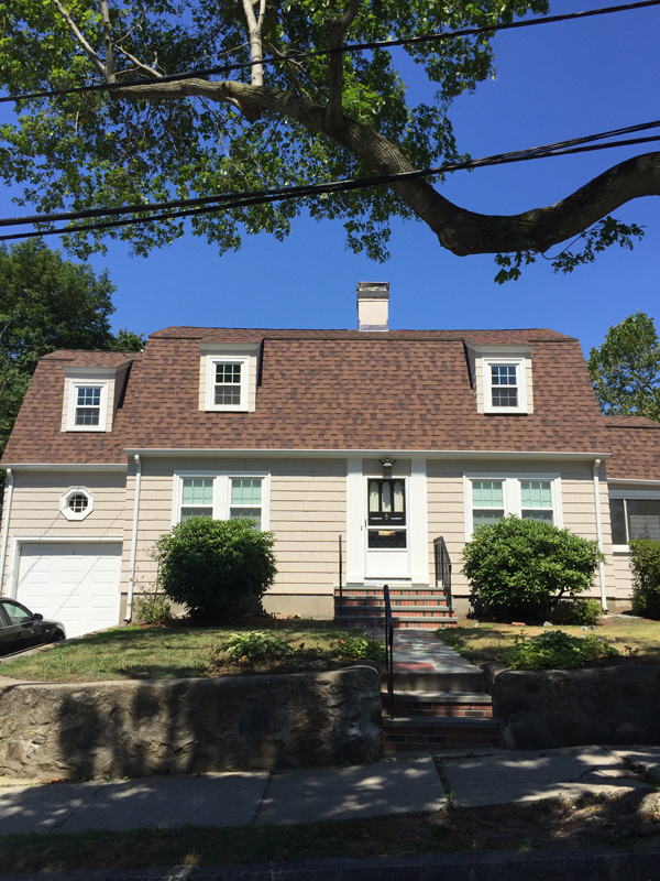 Gambrel-style house with a new brown shingle roof