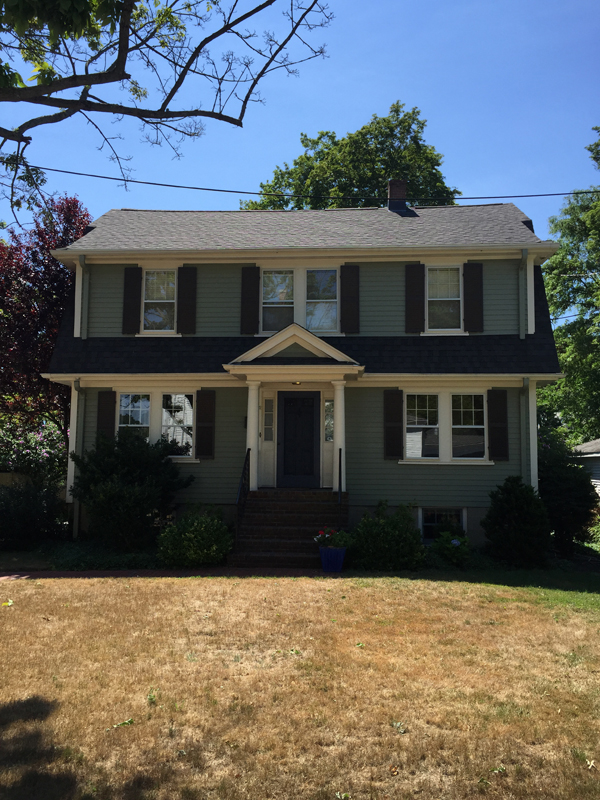 Dark green colonial with a new roof
