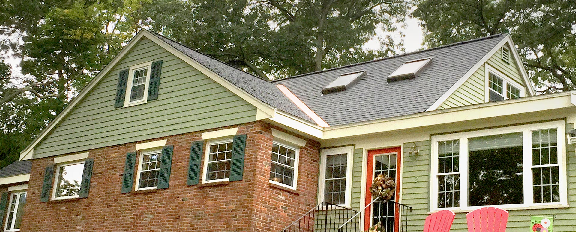 Green and brick house with skylights in a new roof