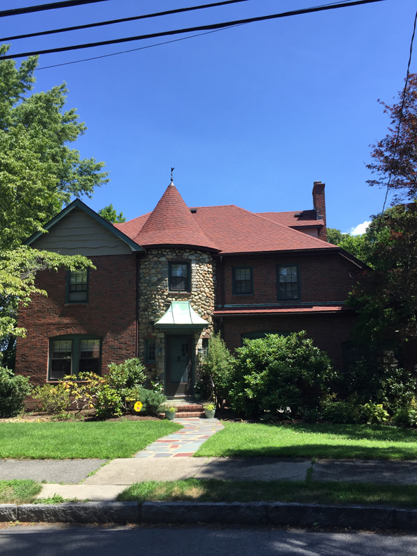 Brick and stone house with a red roof on its turret