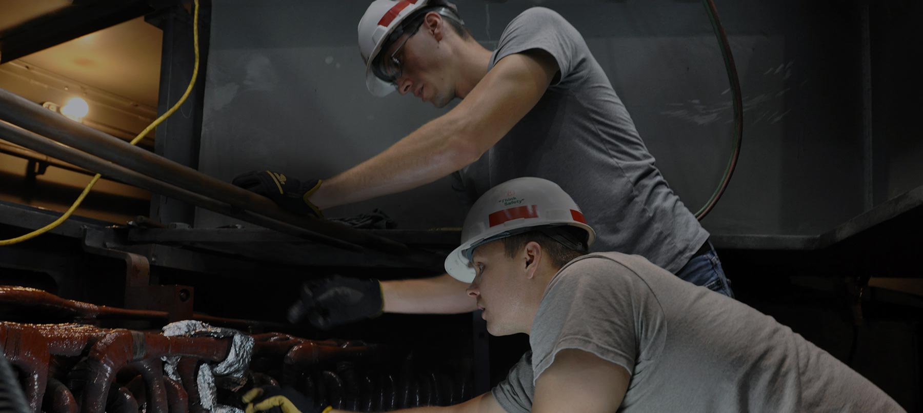 Two Richardson Electrical workers in hard hats working on equipment