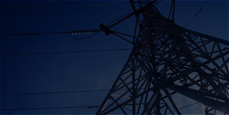 Transmission tower against a deep blue dusk sky