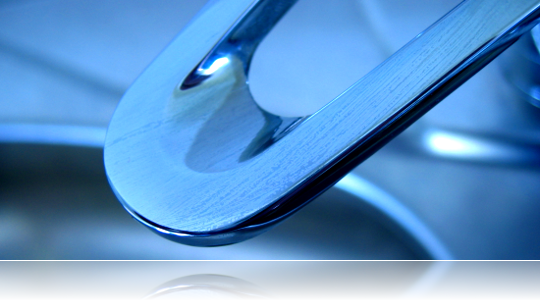 Blue-lit close-up of a polished chrome faucet spout above a sink