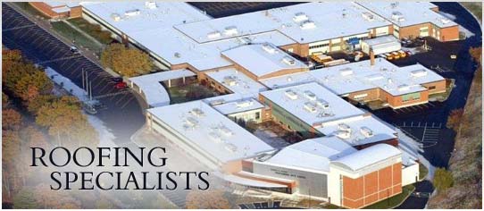 Aerial view of a large low slope commercial roof over a campus of connected buildings