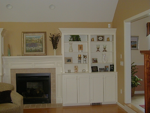 Living room with white built-in cabinets and shelves flanking a fireplace