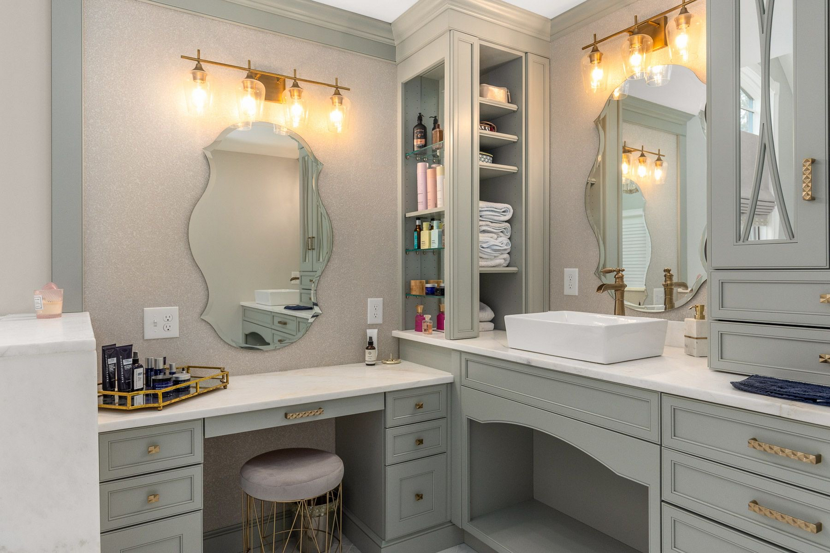 A finished bath with a corner vanity, make-up seat, sconces and stone tops