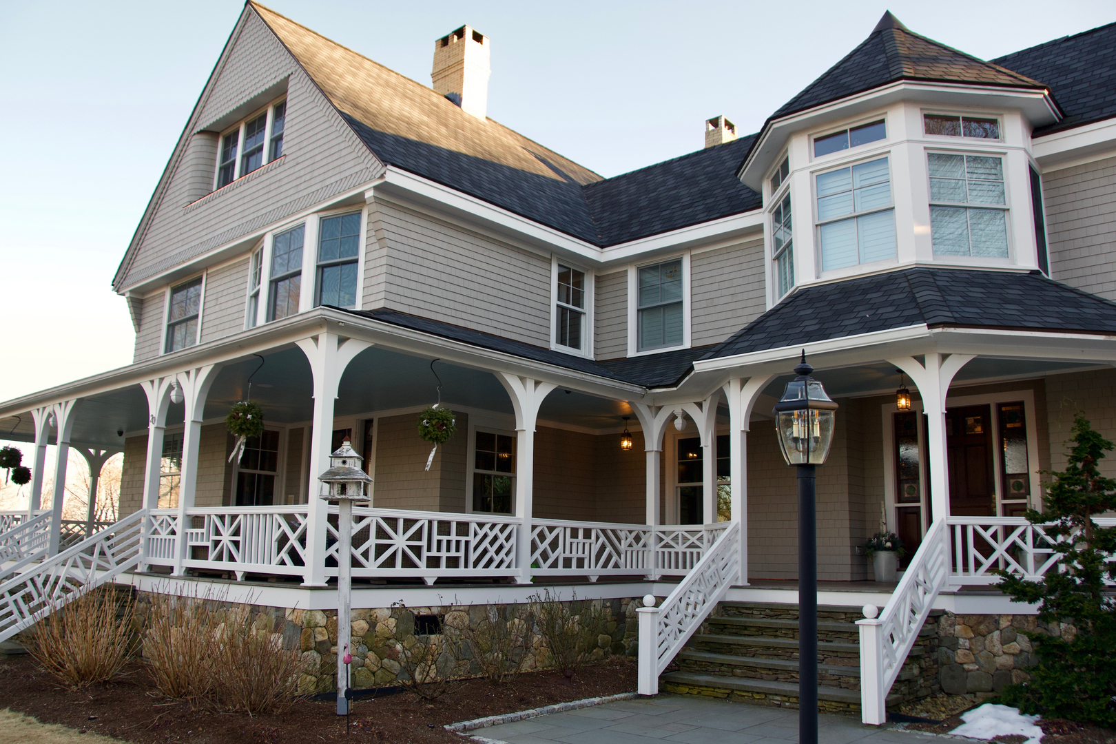 Porch columns, balustrade and bay windows on a shingle style Victorian