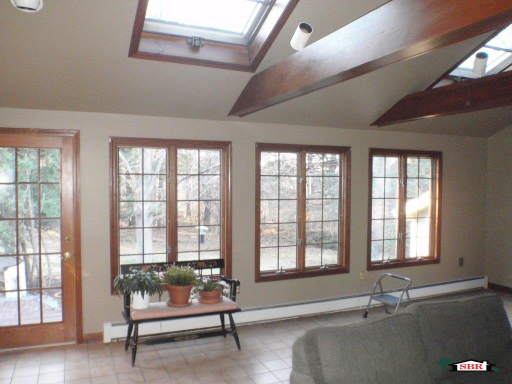 Room with skylights, exposed beams and tall wood casement windows