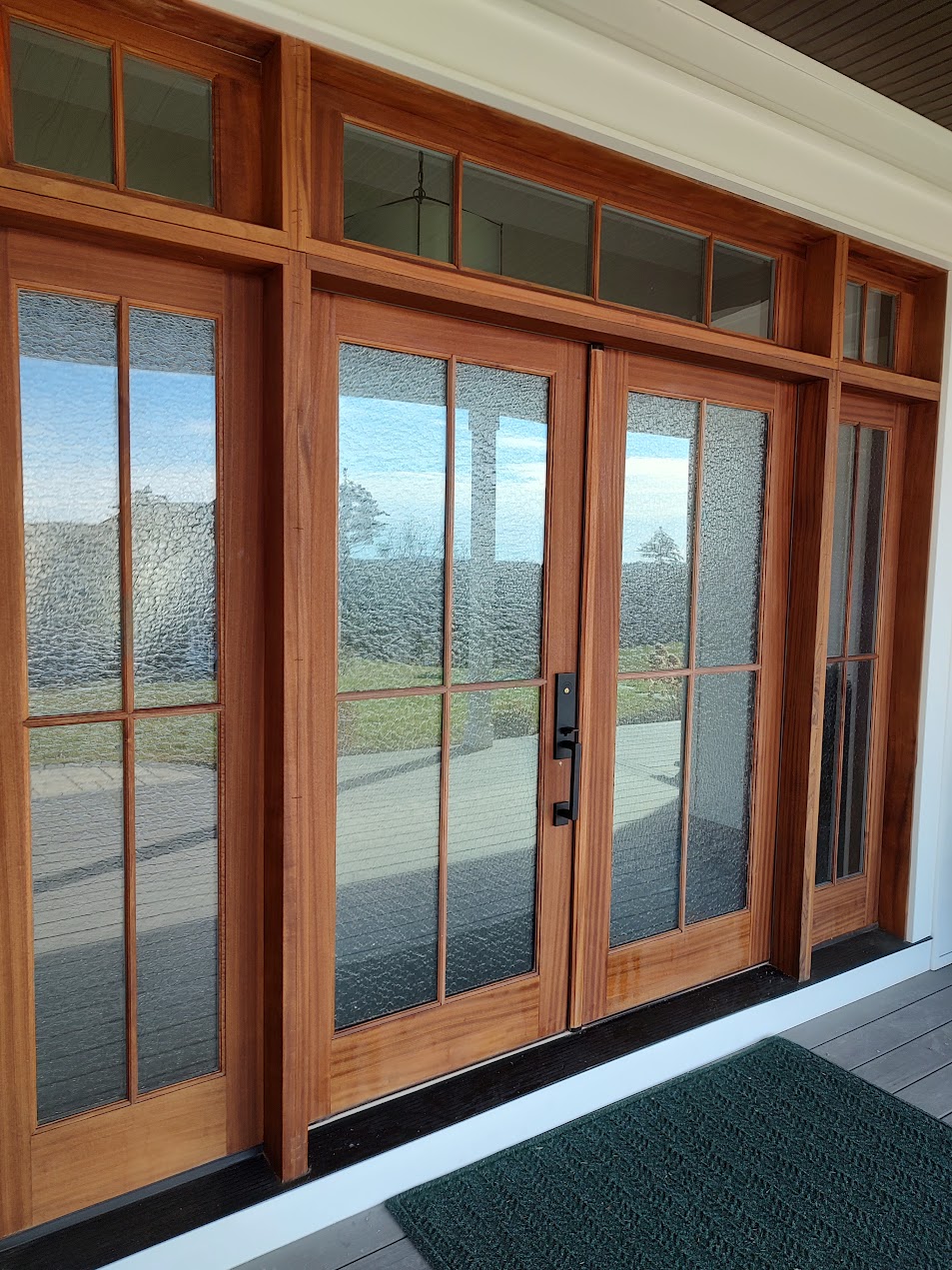 Wood French patio doors with sidelights, seen from a covered entry