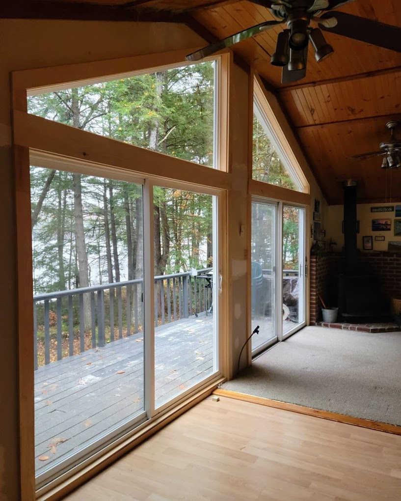 A room with a sliding patio door and a glazed gable wall looking out to a deck