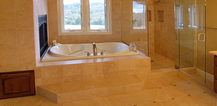 Finished bathroom with a tiled tub deck and a glass shower