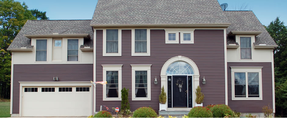 Plum colored colonial with an arched entry and an attached garage