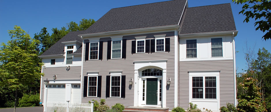 Gray and white colonial with dark shutters and a two bay garage
