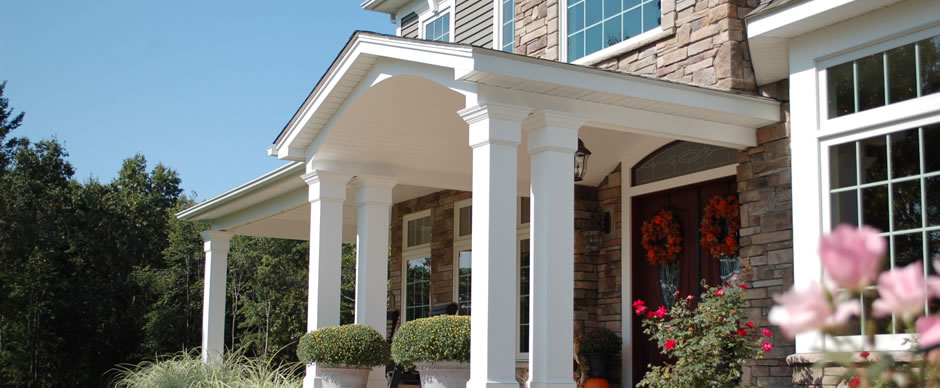Covered front entry with white columns and flowering shrubs