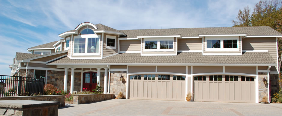 Large tan house with three garage bays and a curved roofline
