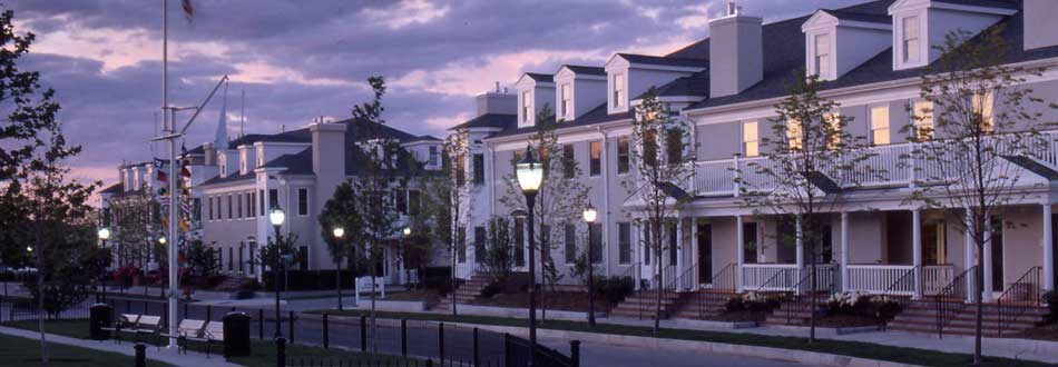 Row of lit Massachusetts townhouses under an evening sky